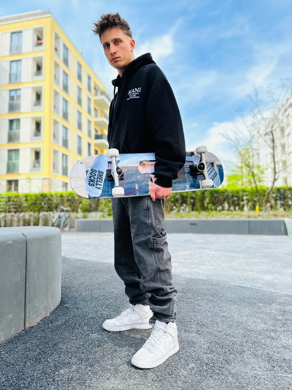 Junge gay skateboarder in Sk8erboy® streetwear showing a SNFF ME sock — a laid-back mix of skate style and gay fetish fashion.