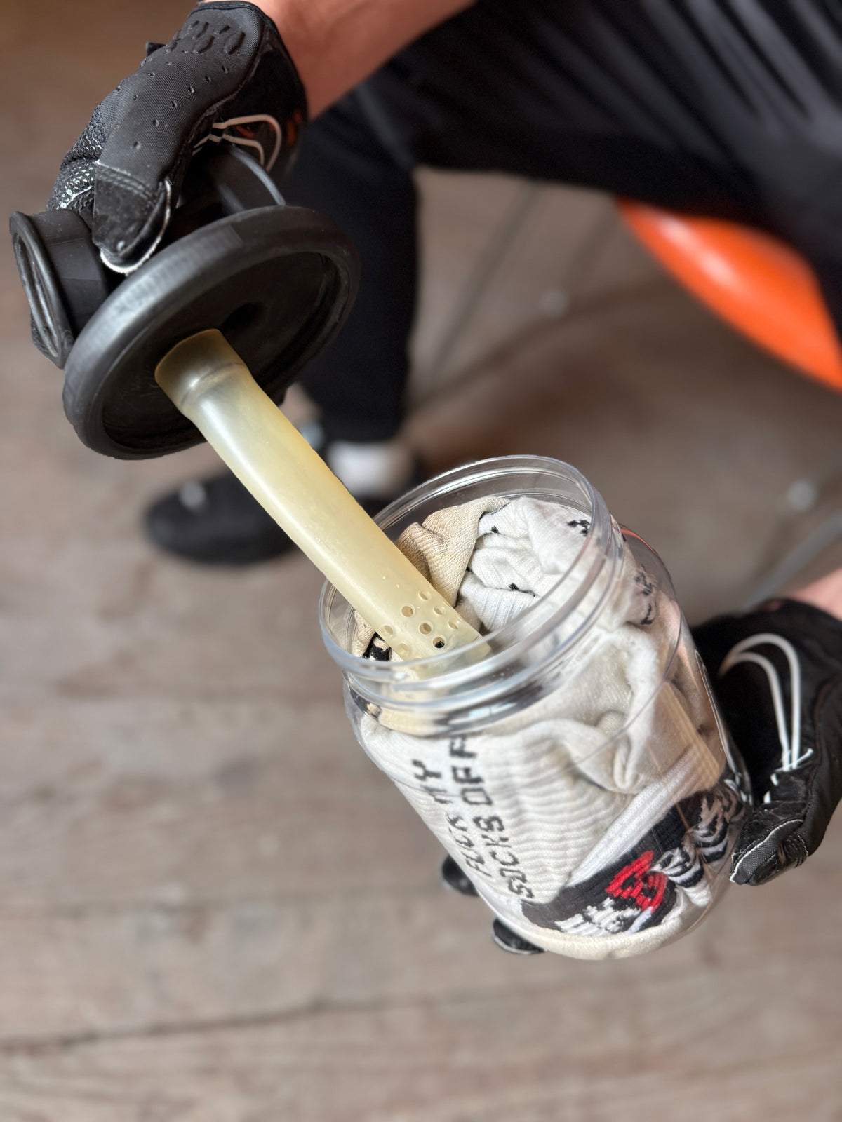 Le bocal Sk8erboy Vast Sniffer s’ouvre, des gants noirs maintiennent le couvercle à filtre au-dessus des chaussettes remplies.