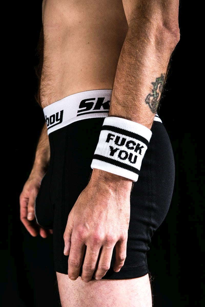 gay dans l'obscurité avec un boxer noir Sk8erboy et un bandeau de sueur au bras gauche avec l'inscription FUCK YOU de Sk8erboy Socken Shop