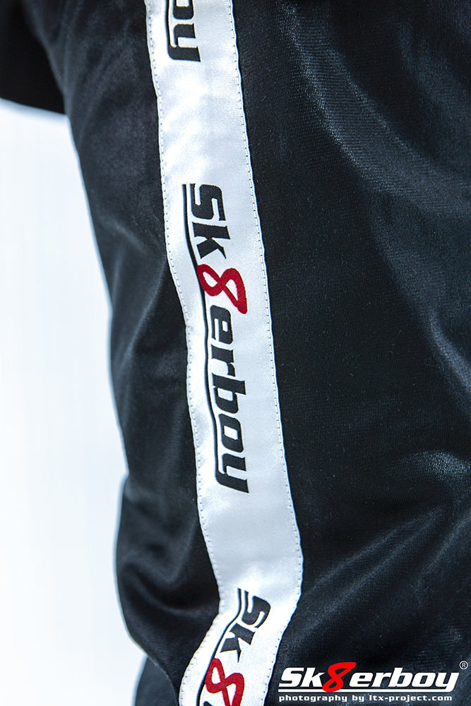 gros plan de côté avec bannière blanche et logo sk8erboy sur le pantalon brillant Shiny Pants pour la maison comme survêtement d'intérieur