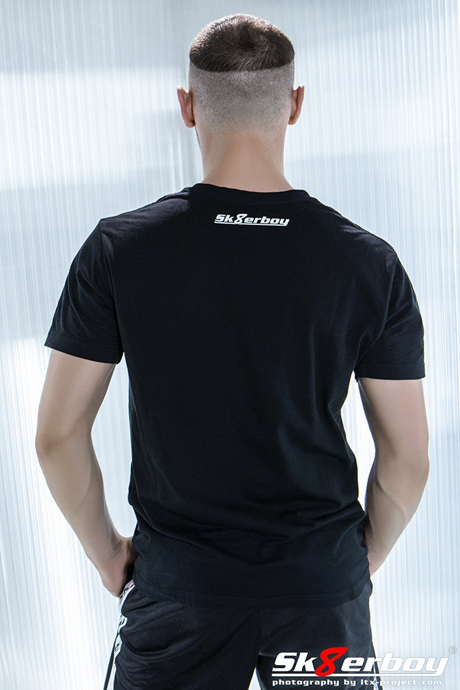 Jeune homme vu de dos avec coupe crew cut et T-shirt Sk8erboy noir, logo dans la nuque et short brillant
