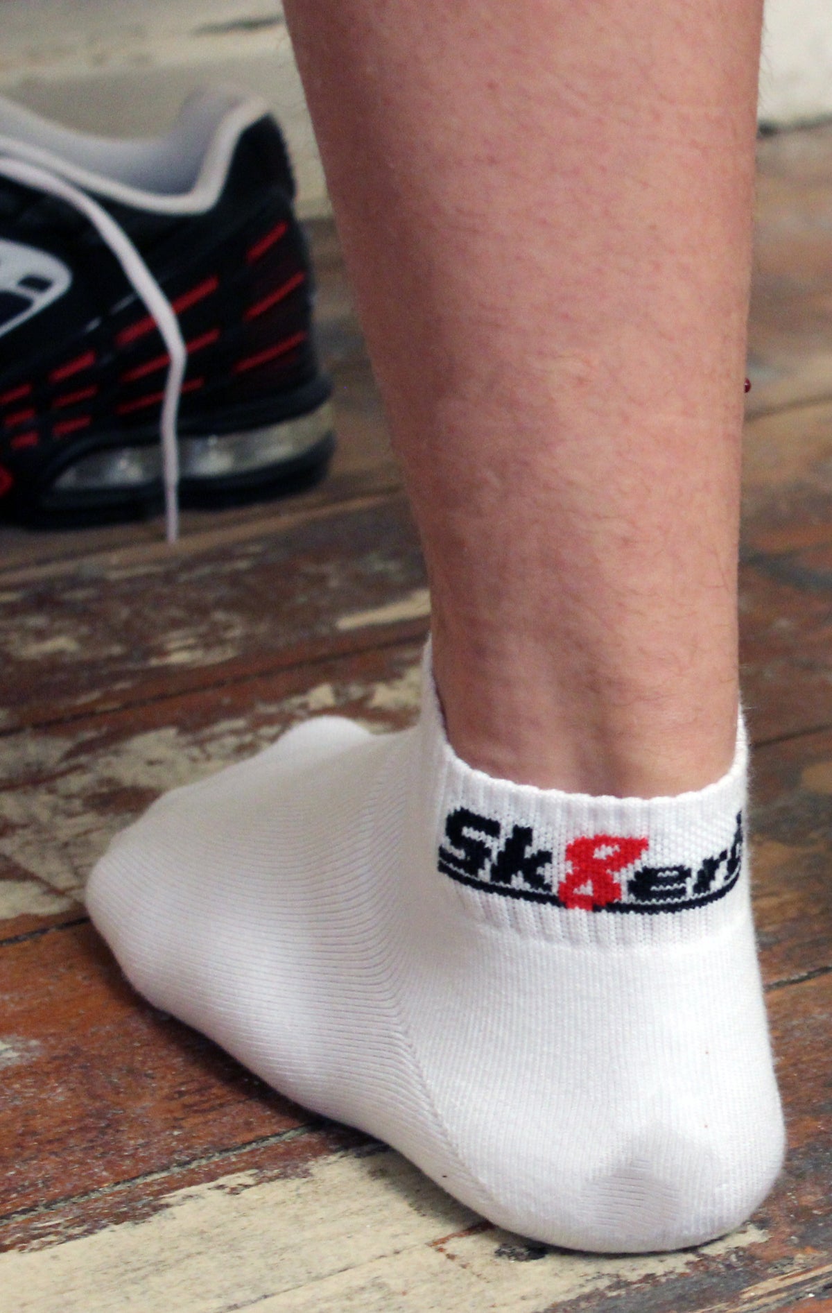 deux pieds avec des chaussettes quarter sk8erboy blanches