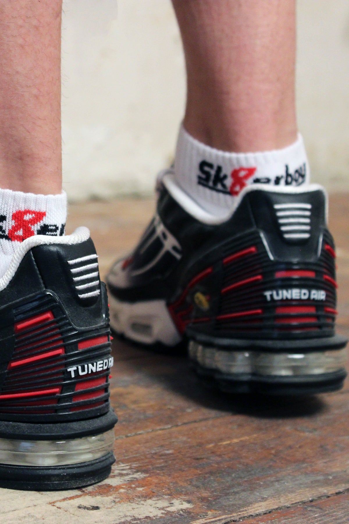 jeune homme gay avec des chaussettes Sk8erboy quarter blanches dans des Nike TN