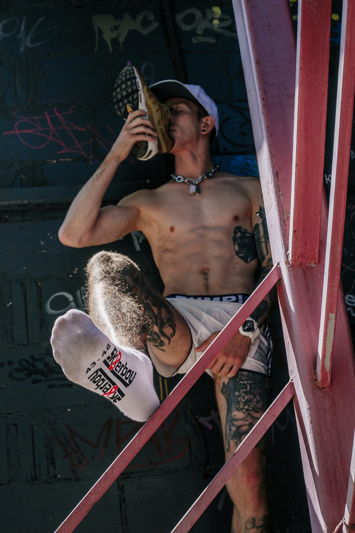young athletic gay man sniffs his sneaker and wears a Nike cap and pumps! jock in white sneaker socks from sk8erboy socks