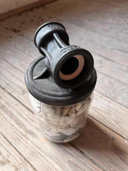 Nahaufnahme eines Sk8erboy Vast Sniffer Glases mit Sockenfüllung und schwarzem Aufsatzdeckel auf dem Holzboden.