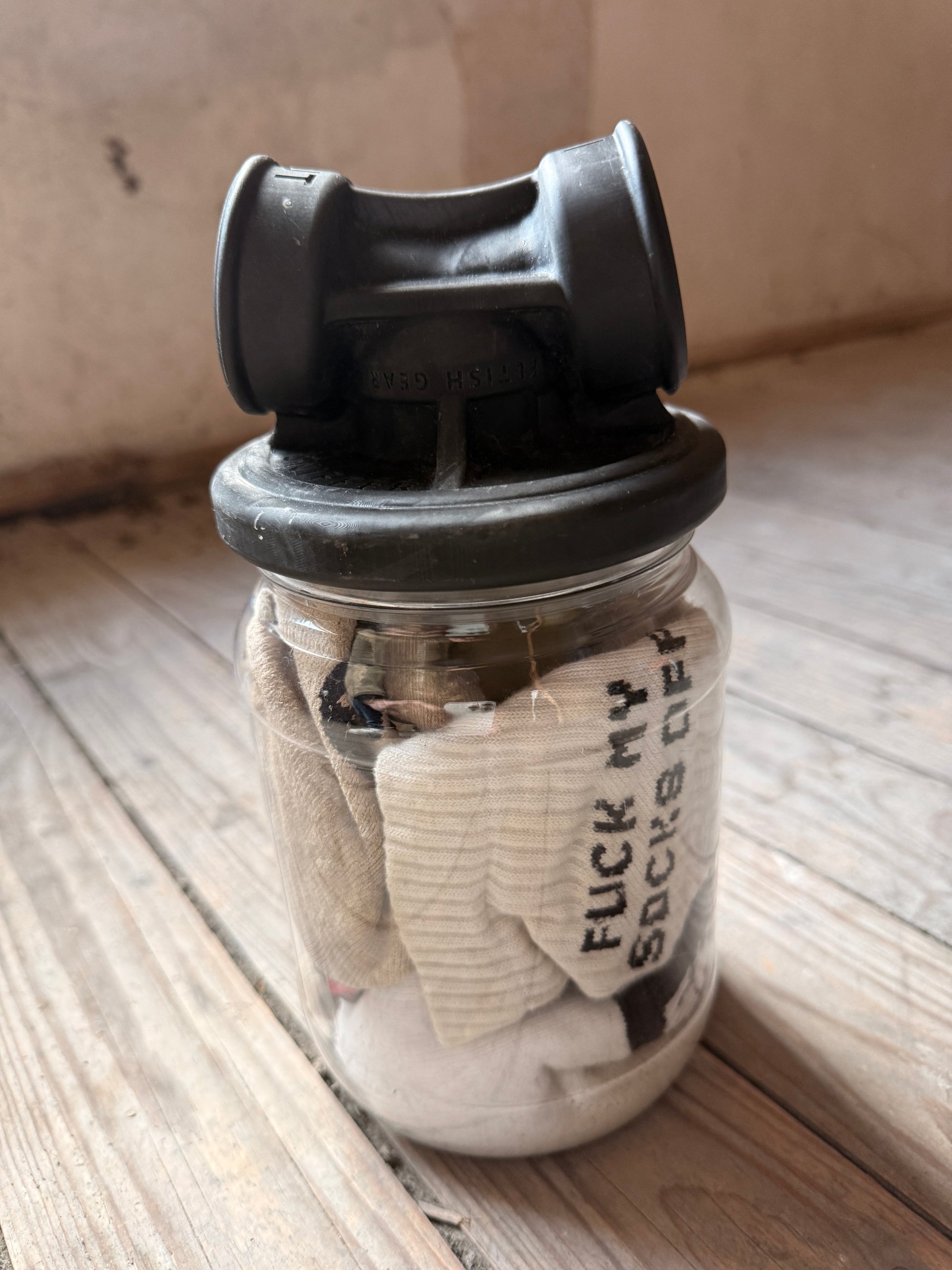 Glas mit Socken, Aufschrift „Fuck my socks off“, verschlossen mit einem Vast Sniffer Aufsatzdeckel.