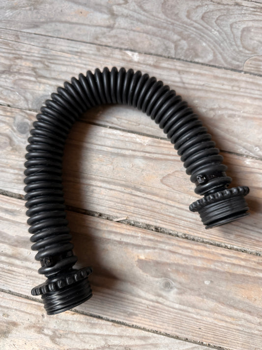 Komplette Ansicht des schwarzen Vast Sniffer Schlauchs in U-Form auf Holz.